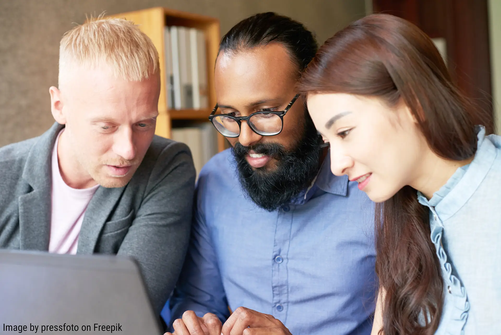 diverse group of young professionals looking at laptop