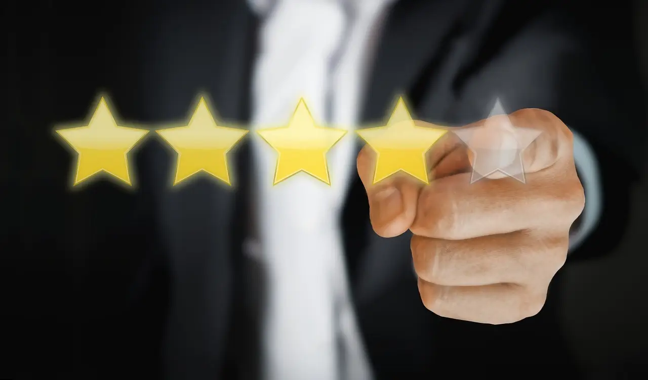 business person's hand in the background selecting 4 out of 5 stars in foreground