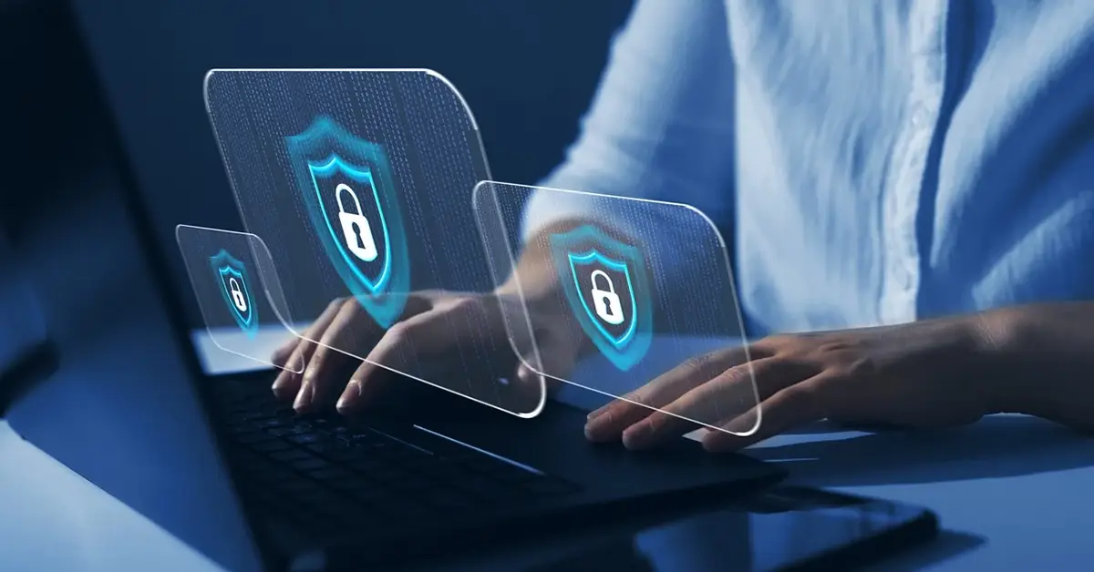 professional working on laptop while floating shields hover over the keyboard