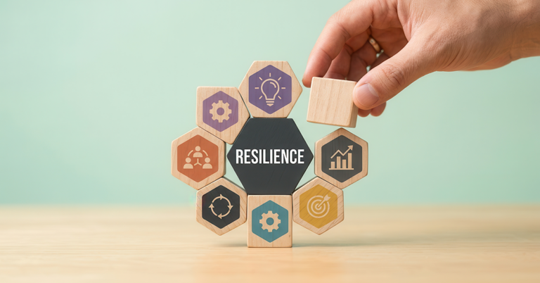 Hand placing a wooden block to build organizational resilience and accelerate growth.